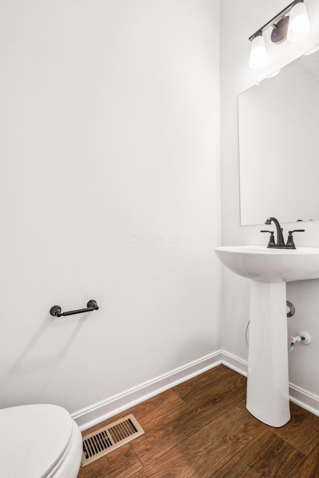 bathroom featuring hardwood / wood-style floors and toilet