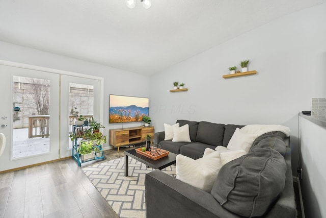 living room featuring light wood-type flooring and vaulted ceiling