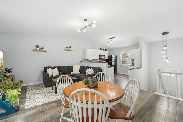 dining area with an inviting chandelier and dark hardwood / wood-style flooring