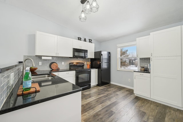 kitchen featuring black appliances, hanging light fixtures, and white cabinetry