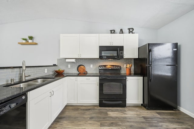 kitchen featuring sink, vaulted ceiling, white cabinetry, and black appliances