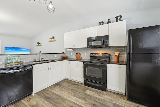 kitchen featuring sink, white cabinetry, lofted ceiling, wood-type flooring, and black appliances