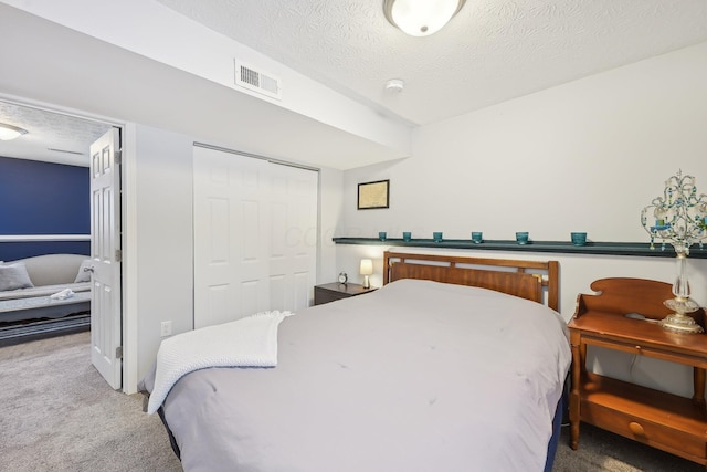 carpeted bedroom with a closet and a textured ceiling