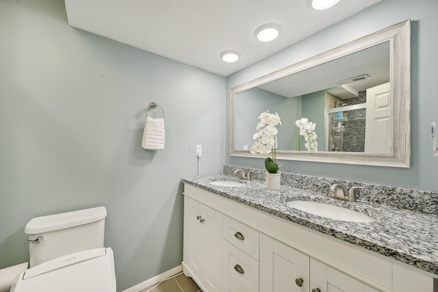 bathroom with toilet, tile patterned flooring, vanity, and walk in shower