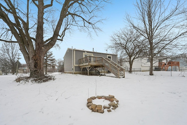 snow covered back of property featuring a deck