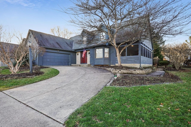 view of front of home with a front yard, a garage, and a sunroom