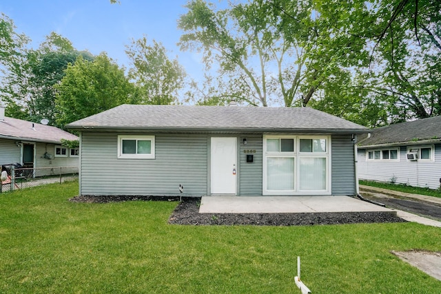 rear view of property featuring a lawn and a patio area