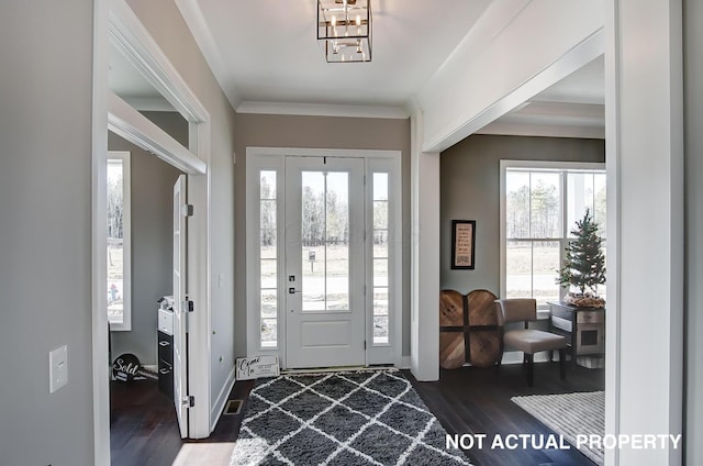 entrance foyer with dark hardwood / wood-style floors and ornamental molding