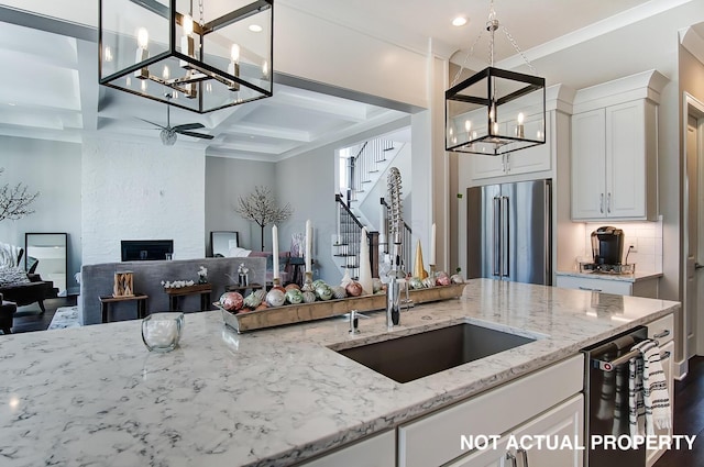 kitchen with white cabinetry, high end refrigerator, a fireplace, and light stone countertops