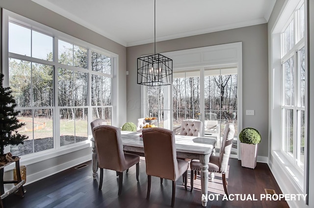 dining area featuring dark hardwood / wood-style floors, a wealth of natural light, and crown molding