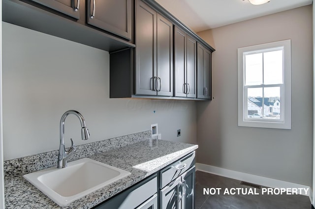 laundry room with sink, cabinets, washer hookup, hookup for an electric dryer, and dark tile patterned flooring