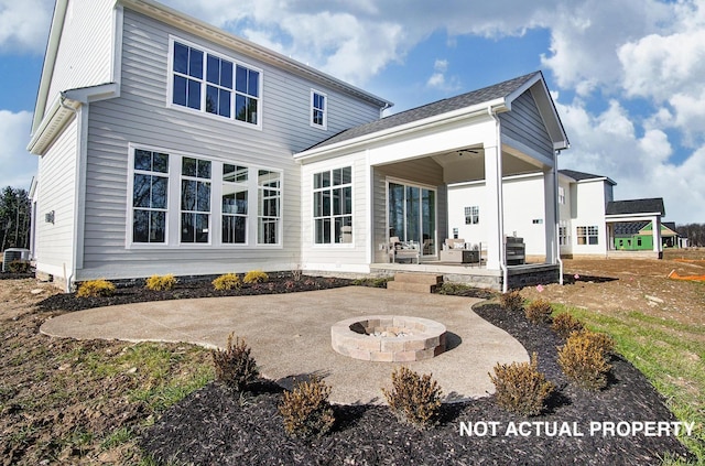 rear view of property featuring a patio area and an outdoor fire pit