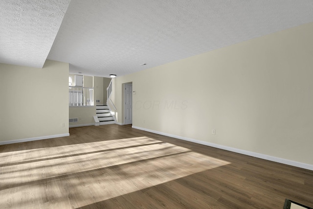 unfurnished living room featuring hardwood / wood-style floors and a textured ceiling