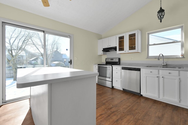 kitchen featuring stainless steel appliances, sink, white cabinets, a kitchen island, and lofted ceiling