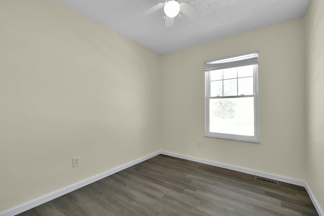 spare room with a textured ceiling, ceiling fan, and dark hardwood / wood-style floors