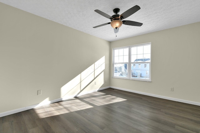 empty room featuring a textured ceiling, ceiling fan, and dark wood-type flooring