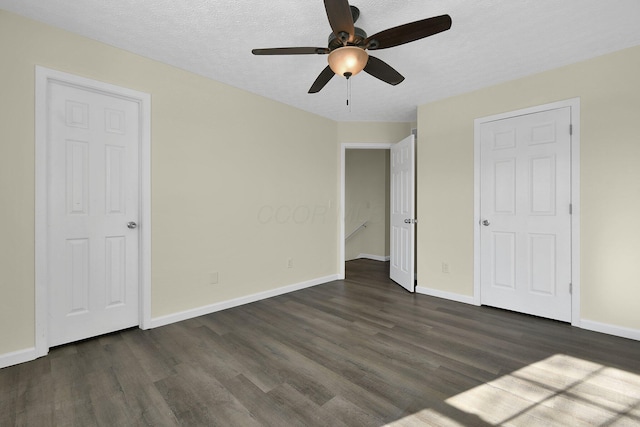 unfurnished bedroom with a textured ceiling, dark hardwood / wood-style flooring, and ceiling fan