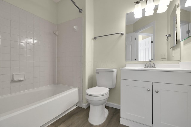 full bathroom featuring hardwood / wood-style flooring, tiled shower / bath combo, toilet, and vanity