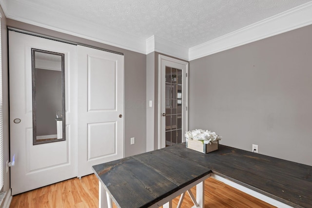 home office featuring hardwood / wood-style floors, ornamental molding, and a textured ceiling