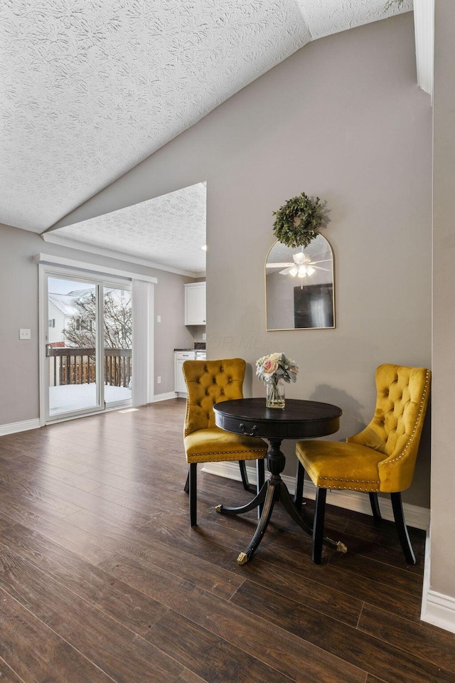 dining room featuring a textured ceiling, dark hardwood / wood-style flooring, and vaulted ceiling