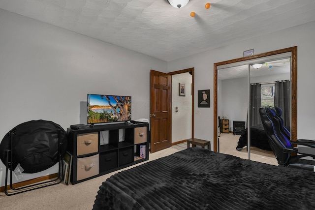 bedroom with a closet, light colored carpet, and a textured ceiling