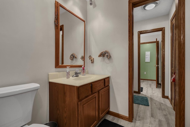 bathroom featuring hardwood / wood-style floors, vanity, and toilet