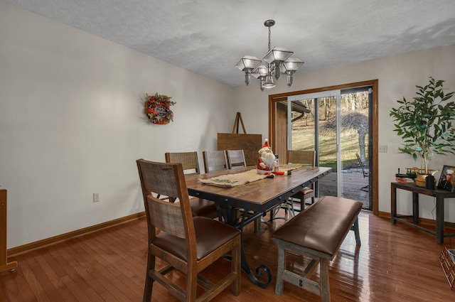 dining room with a notable chandelier, dark hardwood / wood-style floors, and a textured ceiling