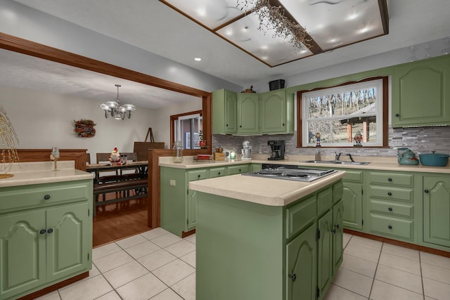 kitchen with a kitchen island, a chandelier, light tile patterned floors, and green cabinetry