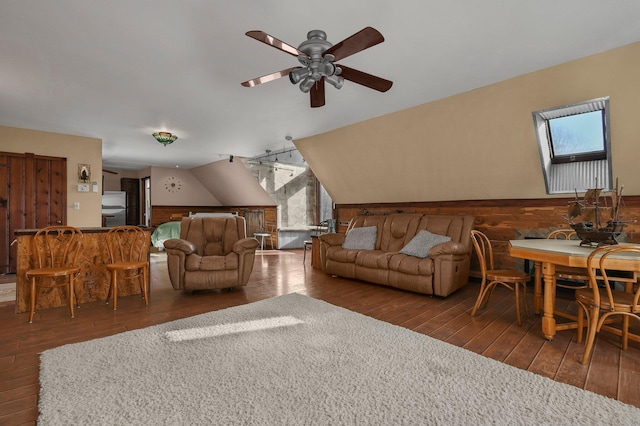 living room featuring ceiling fan, plenty of natural light, and dark wood-type flooring