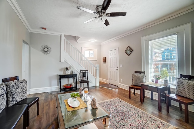 living room with a textured ceiling, dark hardwood / wood-style floors, ceiling fan, and crown molding