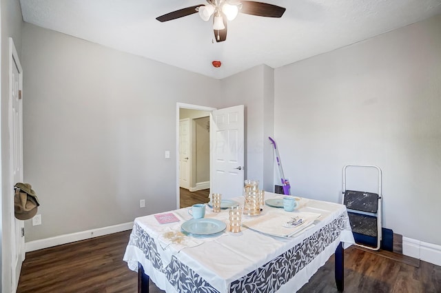 dining space with ceiling fan and dark wood-type flooring