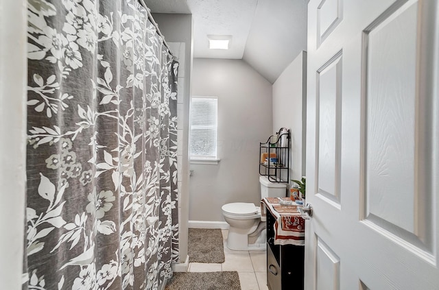 bathroom with toilet, a textured ceiling, tile patterned floors, and lofted ceiling