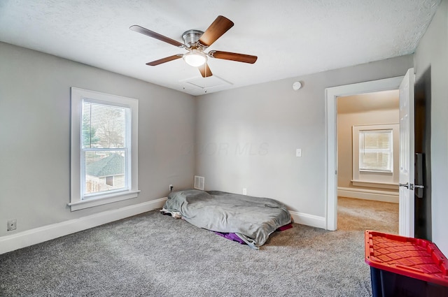 bedroom featuring carpet flooring, ceiling fan, and a textured ceiling