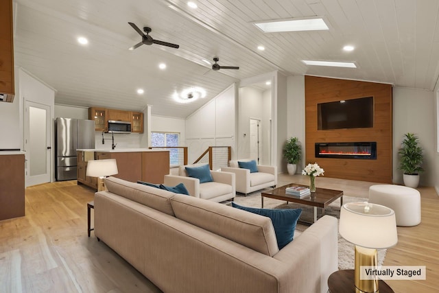 living room with light wood-type flooring, a large fireplace, ceiling fan, wooden ceiling, and lofted ceiling