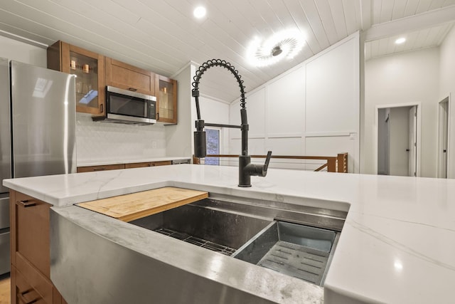 kitchen with appliances with stainless steel finishes, wooden ceiling, and sink