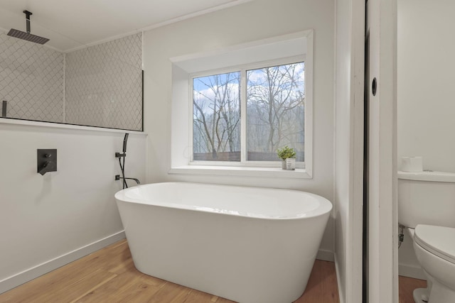 bathroom with a bath, toilet, and hardwood / wood-style floors