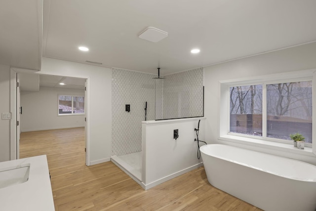 bathroom featuring shower with separate bathtub, vanity, and hardwood / wood-style floors