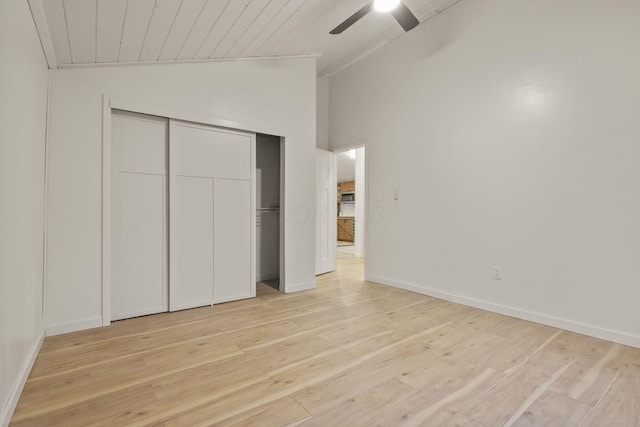 unfurnished bedroom with ceiling fan, high vaulted ceiling, light hardwood / wood-style floors, a closet, and wood ceiling