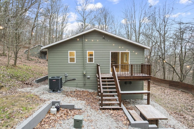 rear view of house with central AC unit and a wooden deck