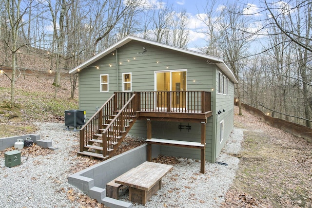 back of house with cooling unit and a deck