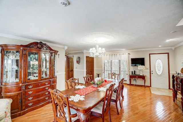 dining area with a notable chandelier, light wood-type flooring, and crown molding