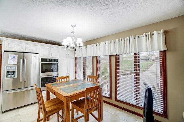 dining room featuring a chandelier, a textured ceiling, and light tile patterned flooring