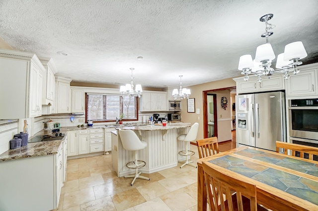 kitchen with a center island, stainless steel appliances, light stone counters, decorative light fixtures, and a breakfast bar area