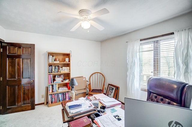 home office featuring light carpet and ceiling fan