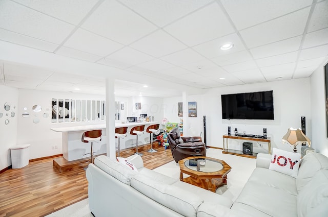 living room featuring a drop ceiling and hardwood / wood-style floors