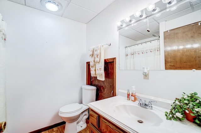 bathroom with a shower with curtain, vanity, toilet, and a paneled ceiling