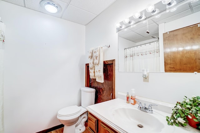 bathroom featuring a paneled ceiling, vanity, toilet, and a shower with curtain