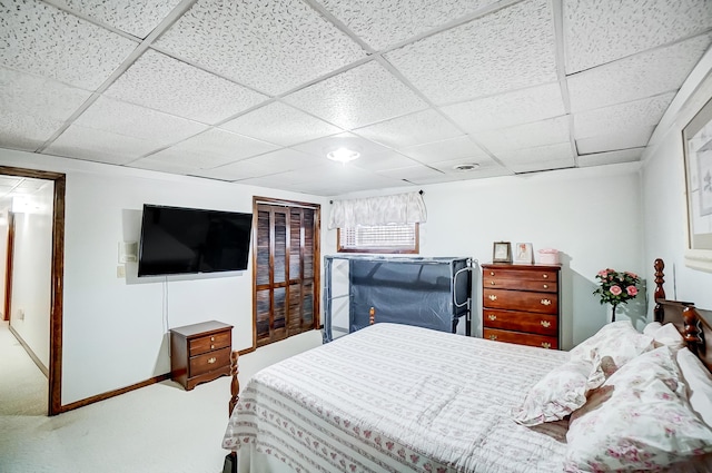 carpeted bedroom featuring a drop ceiling