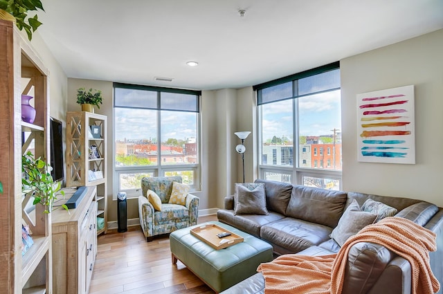 living room featuring light wood-type flooring and floor to ceiling windows