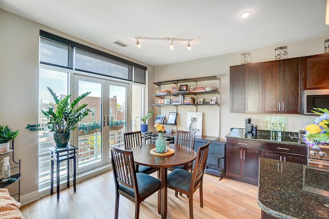 dining space with french doors and light hardwood / wood-style flooring